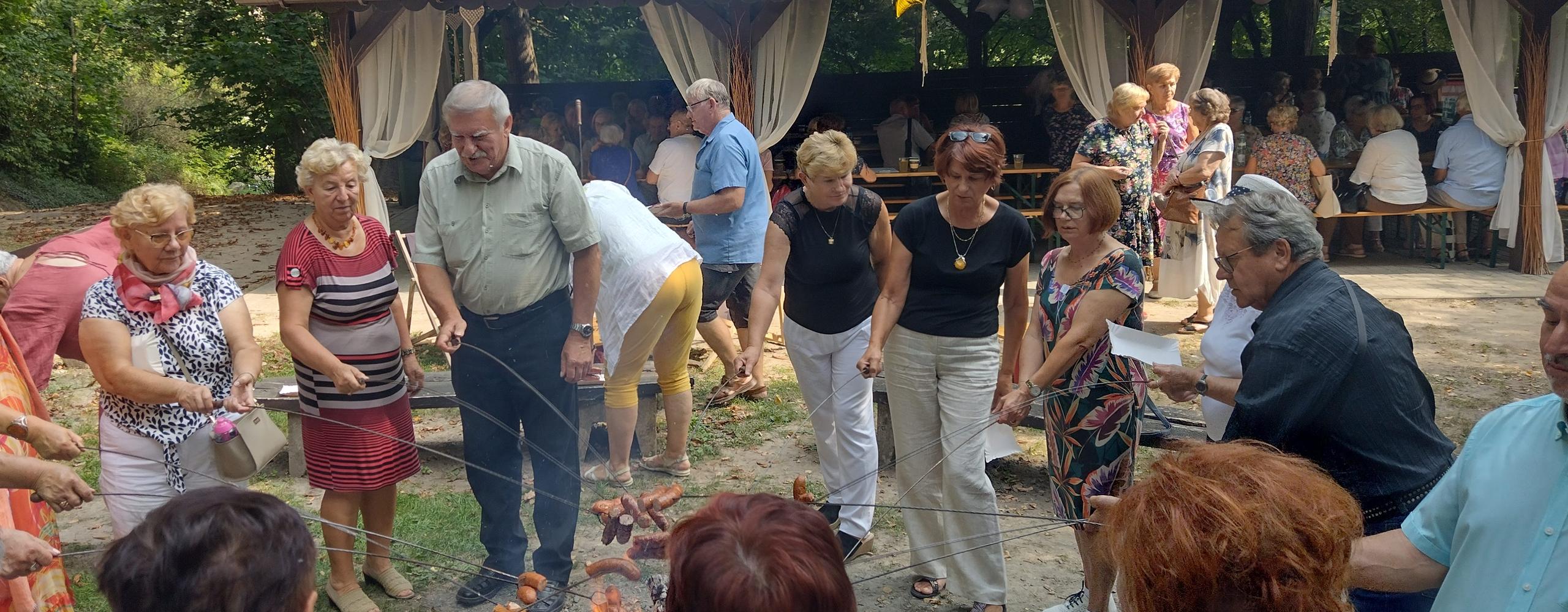 Pieczenie kiełbasek przy ognisku podczas pikniku integracyjnego
